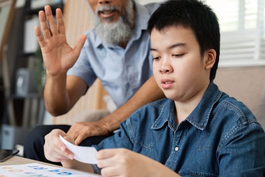 A grandfather interacts with his grandson during drawing time, providing support and encouragement, highlighting the significance of family involvement in creative learning.