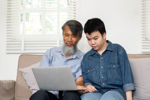 A collaborative learning experience as a grandfather and grandchild focus on a laptop, sharing knowledge and fostering a supportive environment.