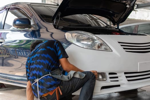 Denter or car mechanic serviceman check and fix body work and fiber bumper body part for fix and repair problem at car garage or repair shop