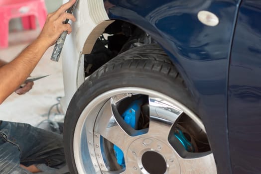Denter or car mechanic serviceman check and fix body work and fiber bumper body part for fix and repair problem at car garage or repair shop