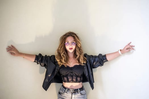 thoughtful young woman stands in front of a wall