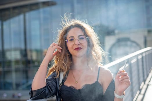 smiling young woman with cigarette in the city