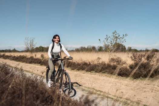 Sunlit motion as a smiling woman in light clothes rides her bike, radiating health, energy, and a pure love for the outdoors.
