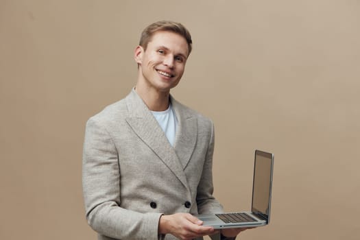 Smiling man working with laptop hold open notebook showing cybersecurity concept casual jacket on beige background digital nomad technology usage cybersecurity protection business communication. Concept: cybersecurity awareness