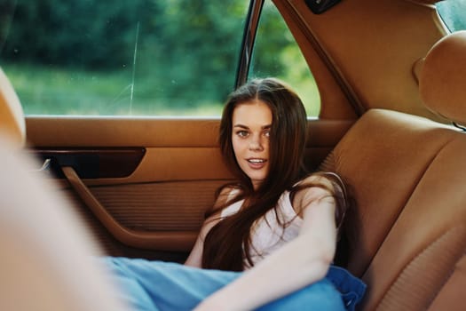 A young woman with long hair enjoying her time in a vintage car, radiating carefree emotions. The warm color palette and lush green background evoke a sunny summer day, ideal for lifestyle and travel