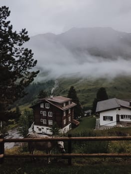 House on top of a mountain with clouds and sunset on the background