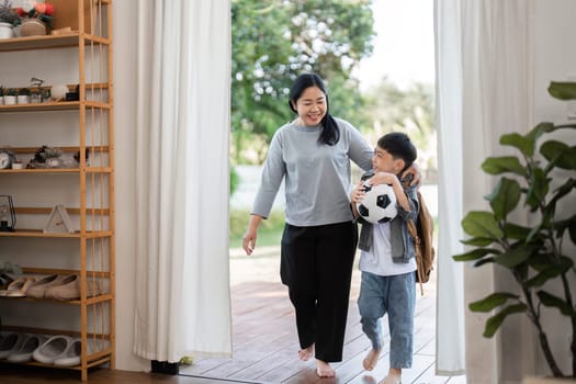A mother and her son step outside, ready for school, embodying the spirit of adventure and learning as they embrace the day ahead.