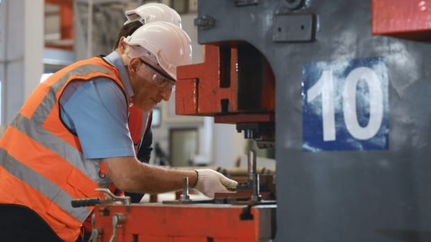 Two engineers talking together in roof steel metal manufacturing factory industry, engineering worker man standing explaining for maintain of metal sheet stamping machine, teamwork concept