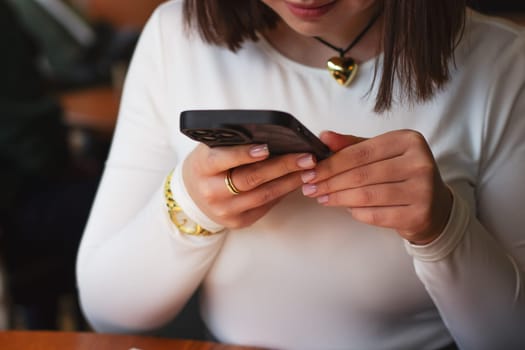 Young woman with phone in coffee shop. High quality photo