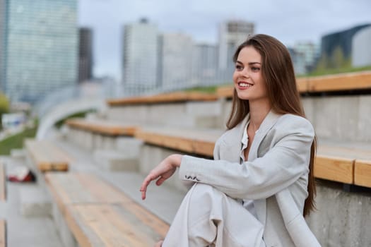 Businesswoman in a stylish gray suit, seated on outdoor bleachers, exuding confidence and professionalism, perfect for corporate, business, and empowerment themes.