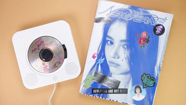 K-pop group NewJeans Album photobook on yellow. Music CD player. South Korean girl group NewJeans. Space for text. Gatineau, QC Canada - March 16 2024