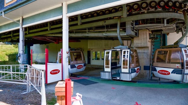 Mont-Tremblant QC Canada - 22.09.2024: Three Empty Cable Railway Cabins at a Mountain Station Platform with Green Floor and White Walls.