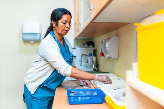 Nurse wearing gloves is preparing medication for residents in a nursing home treatment room, ensuring safety and proper dosage for elderly care