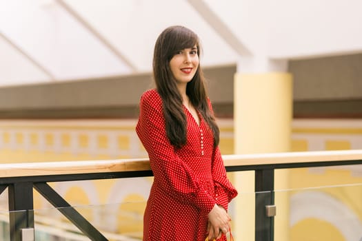 Young woman standing with shopping bags in mall. Retail therapy and consumer lifestyle theme.