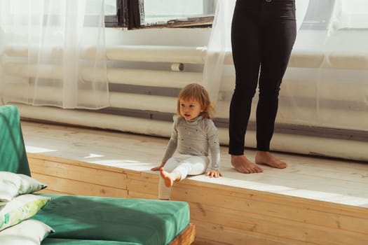 Little child playing indoors while parent works remotely. Family life and work from home concept