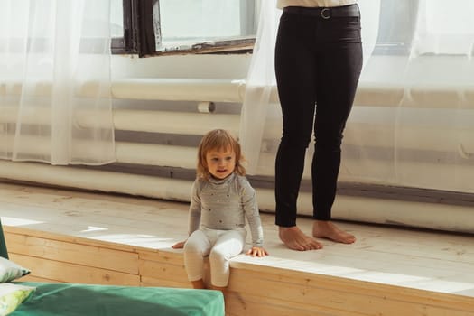 Little child playing indoors while parent works remotely. Family life and work from home concept
