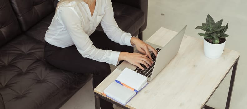 Banner Businesswoman working remotely with laptop at home. Freelance, productivity and digital lifestyle concept. Copy space.