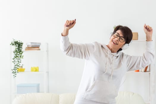 Energetic woman dancing at home while enjoying music. Lifestyle, movement and positive emotions concept