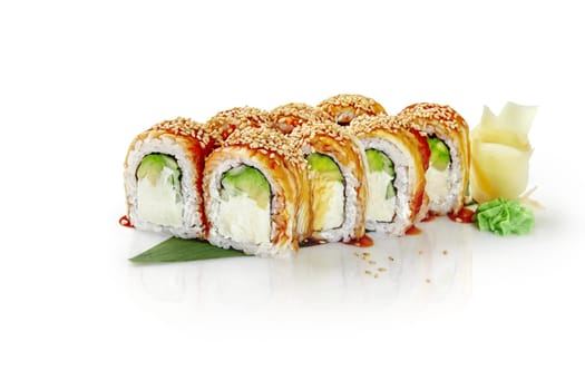 Sushi roll with smoked eel, avocado, cream cheese and sesame seeds lying on a bamboo leaf with wasabi and ginger