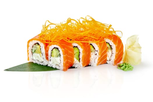 Delicious philadelphia uramaki sushi rolls are garnished with crispy onions and served on a bamboo leaf with wasabi and pickled ginger