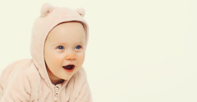 Portrait of happy cute baby crawling on the floor on white studio background