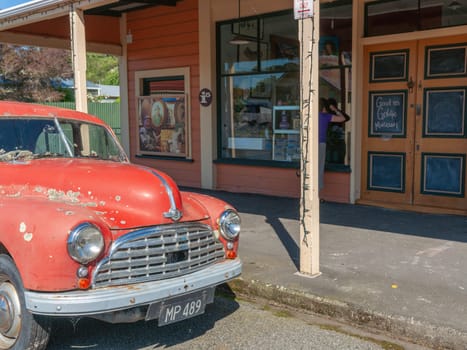 Mangaweka New Zealand - November 30 2011; Street and buildings of Mangaweka old red Morris Minor parked outside small town New Zealand building in Manawatu-Wanganui region New Zealand.
