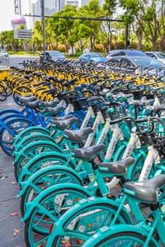 Shanghai, China - 1 April 2025: Close-up of blue shared bicycles lined up. Cars in background. Minimal urban scene without pedestrians
