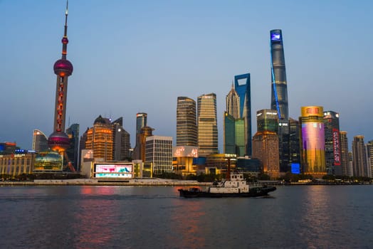 Shanghai, China - 1 April 2025: Editorial night skyline view of Pudong district at sunset across the Huangpu River, featuring the Oriental Pearl Tower and financial center