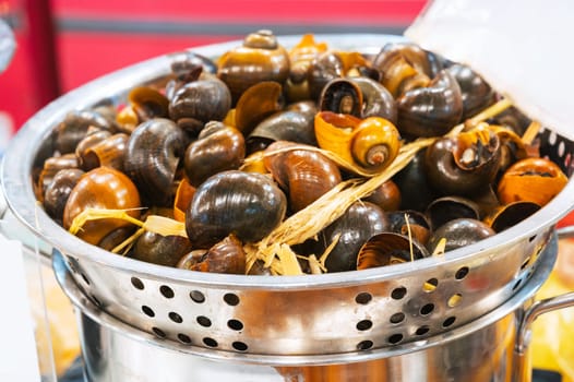 Boiled snails at the Asian night market in Asia. Traditional Vietnamese street food in Vietnam
