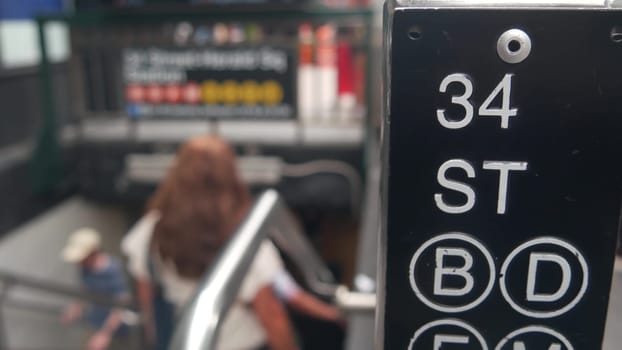 New York City, United States - 29 Aug 2023: Subway sign, underground metro station. Metropolitan entrance, Manhattan public transport. Pedestrians people. 34 street, Penn Station, passenger railroad.