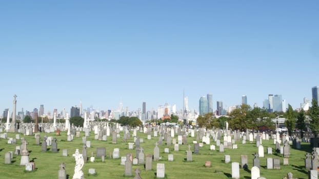 New York City, United States - 14 Sept 2023: Calvary cemetery in Queens, USA. Manhattan Midtown urban skyline cityscape architecture. Tombstones on graves, huge graveyard. Large cemetry grass lawn.
