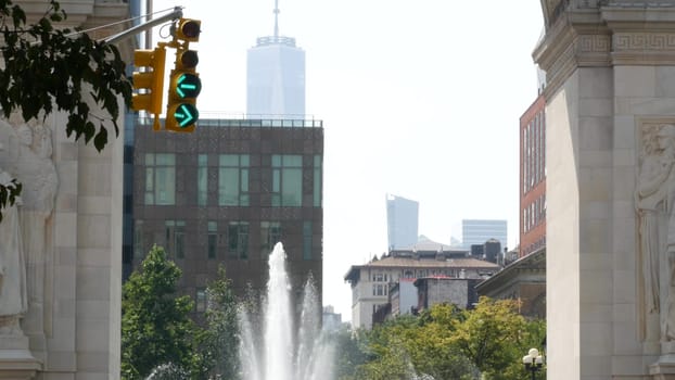 New York City, United States - 8 Sep 2023: Street crossroad, yellow traffic light, transport road intersection, United States. Washington Square Arch and fountain. World Trade Center. 5 Fifth Avenue.