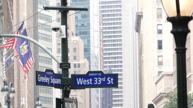 New York City, United States, 29 Aug 2023: Manhattan crossroad, street intersection road sign. Midtown district, Broadway highrise architecture. Greeley roadsign, Herald Square, american flag on Macys