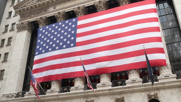 New York City, United States - 9 Sept 2023: Lower Manhattan Downtown Financial District urban architecture. Huge big American flag. Wall street Stock Exchange building, USA Stock Market trading.