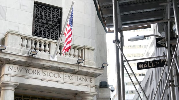 New York City, United States - 4 Sept 2023: Lower Manhattan Downtown Financial District architecture. Wall street road sign near Stock Exchange building, USA Stock Market. Scaffolding, American Flag.