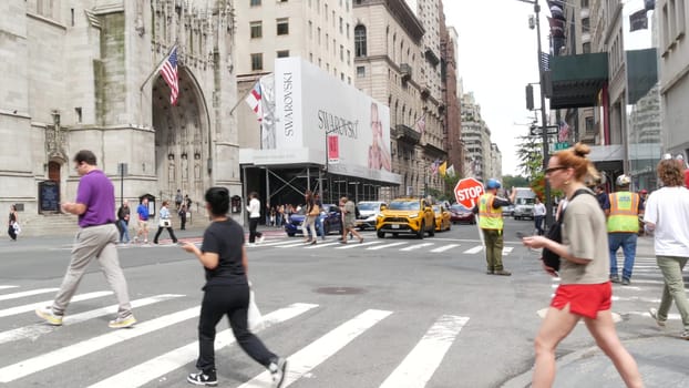 New York City, United States - 11 Sept 2023: Manhattan Midtown street, Fifth 5 avenue, 5th ave, American road car traffic, Yellow taxi cab. People pedestrians, zebra crosswalk, crossroad intersection.