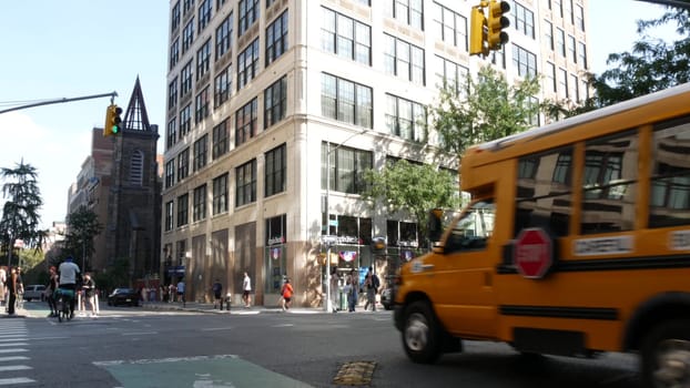 New York City, United States - 6 Sept 2023: Yellow School Bus on Manhattan street, schoolbus, taxi and police car on avenue. Children education, road transportation, NYPD USA. American school shuttle.