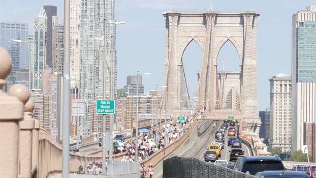 New York City, United States - 3 Sept 2023: Cars on Brooklyn Bridge from Manhattan downtown to Dumbo. Financial district skyline cityscape. Road traffic, people walking and USA architecture.