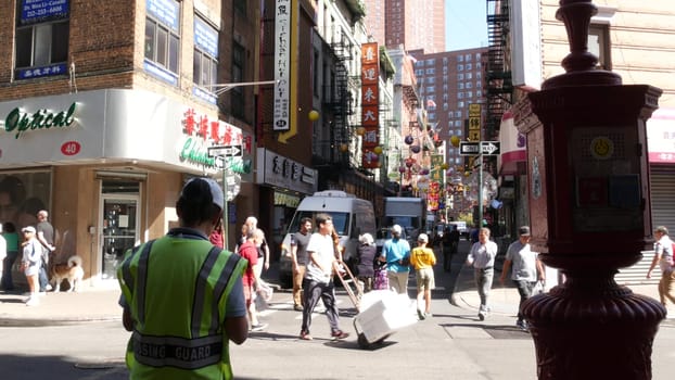 New York City, United States - 14 Sept 2023: Manhattan Chinatown Pell, Mott street. Chinese culture, ethnic district architecture, USA. Red brick buildings, paper lanterns and hieroglyph signs. People