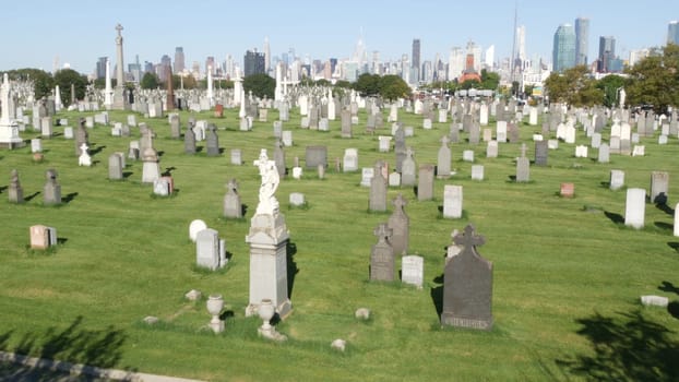 New York City, United States - 14 Sept 2023: Calvary cemetery in Queens, USA. Manhattan Midtown urban skyline cityscape architecture. Tombstones on graves, huge graveyard. Large cemetry grass lawn.