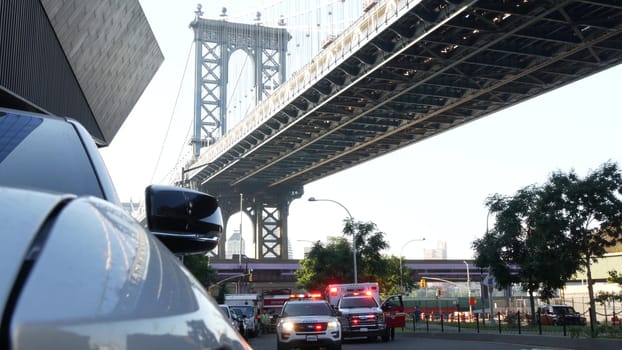 New York City, United States - 7 Sept 2023: NYFD Ambulance medical emergency, fire department paramedic truck. Manhattan bridge. Police patrol car, USA NYPD 911 vehicle on street. American cop siren.