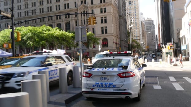 New York City, United States - 31 Aug 2023: Police patrol car, USA NYPD, 911 vehicle on Manhattan Downtown street. American cop auto siren light. Urban traffic, road transport scene. Yellow taxi cab.