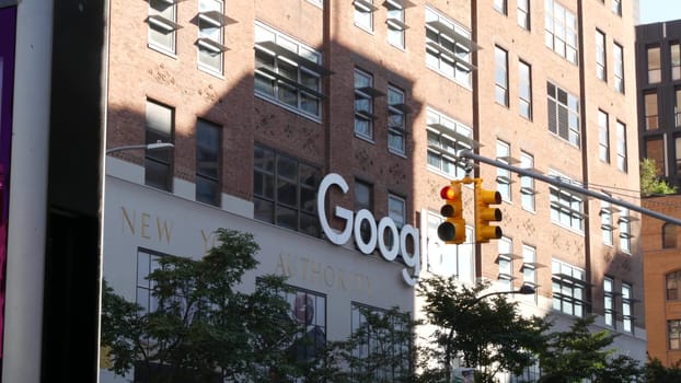 New York City, United States - 1 Sept 2023: Manhattan Midtown street or avenue. Urban red brick architecture USA. Google logo. Headquarters office near Chelsea Market, High Line. Yellow traffic light.
