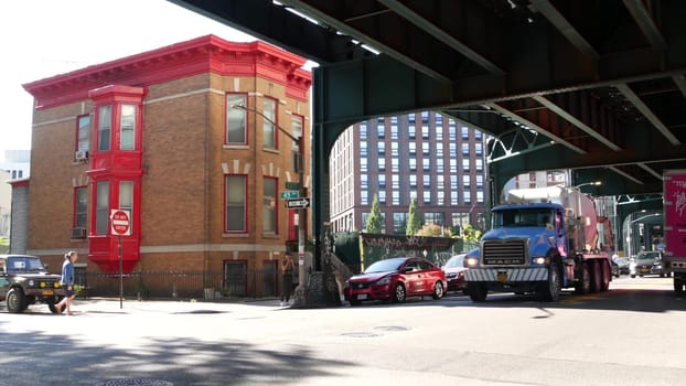 New York City, United States - 31 Aug 2023: Elevated subway above street. Metropolitan bridge over road, Queens. Long Island metro line, Court Square. Cars under metallic railway track. NYC urban life