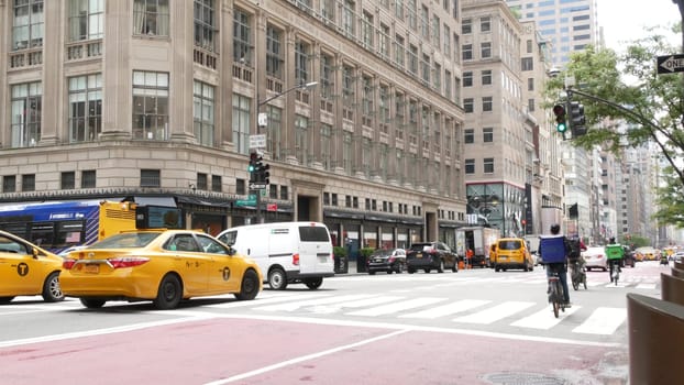 New York City, United States - 11 Sept 2023: Manhattan Midtown street, Fifth 5 avenue. American urban road car traffic, crossroad intersection. Yellow taxi cab in USA. People pedestrians go shopping.