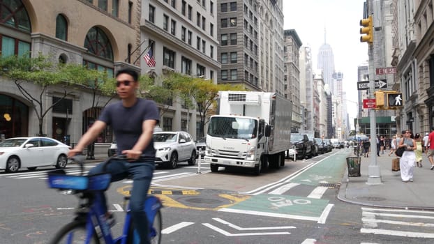 New York City, United States - 8 Sept 2023: Manhattan Midtown street, Fifth 5 avenue. American urban road car traffic, USA. People pedestrians, Empire State Building. UPS brown delivery truck, DHL van