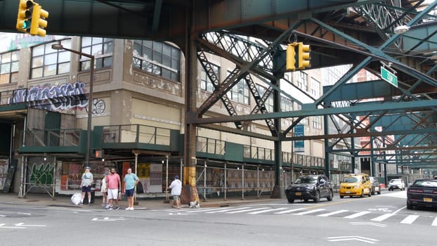 New York City, United States - 2 Sept 2023: Elevated subway over city street. Metropolitan bridge over road, Queens. Long Island overhead metro line, United States. Car under railway track. Queensboro