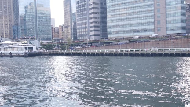 New York City, United States - 31 Aug 2023: Manhattan midtown skyline from ferry boat. Highrise skyscrapers from ferryboat. East river waterfront panorama, riverfront buildings architecture near water