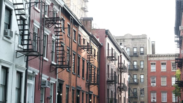 New York City, United States - 10 Sept 2023: Building architecture. Urban residential house exterior. Real estate property, USA. Red brick facade. Greenwich Village Gay street. Fire escape ladder exit