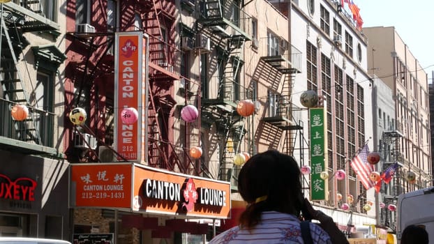 New York City, United States - 14 Sept 2023: Manhattan Chinatown Mott street, chinese ethnic district buildings architecture, USA. Red round paper lanterns, people and hieroglyph signs. Little China.
